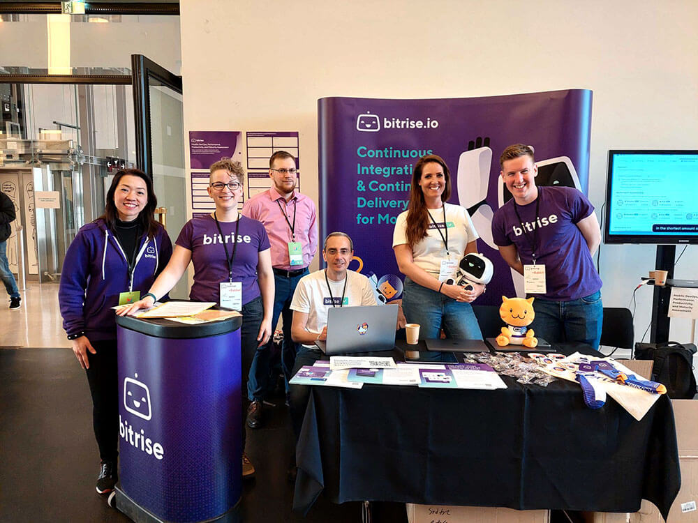 Six Bitrise Employees at a Convention Booth